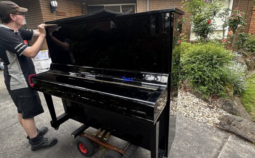 JM & SONS Piano Movers preparing an upright piano on a specialist trolley outside a Melbourne home