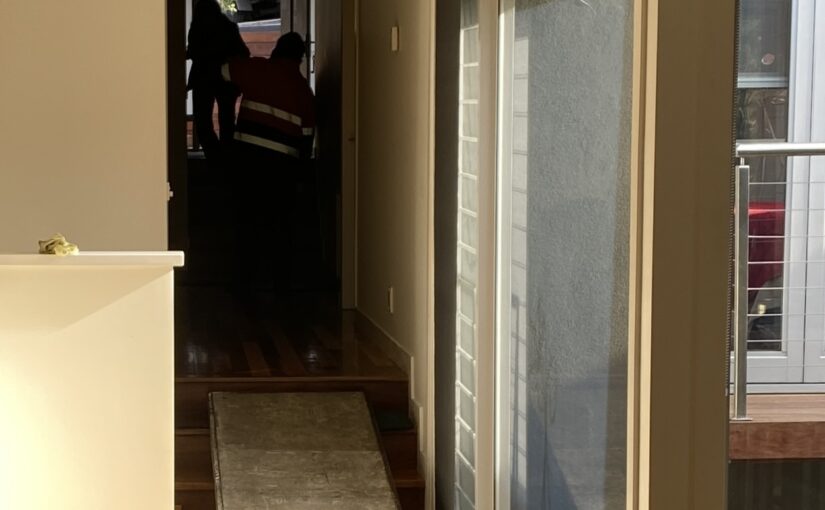 JM & SONS Piano Movers using protective floor coverings and a ramp while moving a piano through a Melbourne home